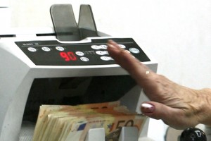 O casiera numara bancnote EURO, intr-o casa de schimb valutar, in Bucuresti